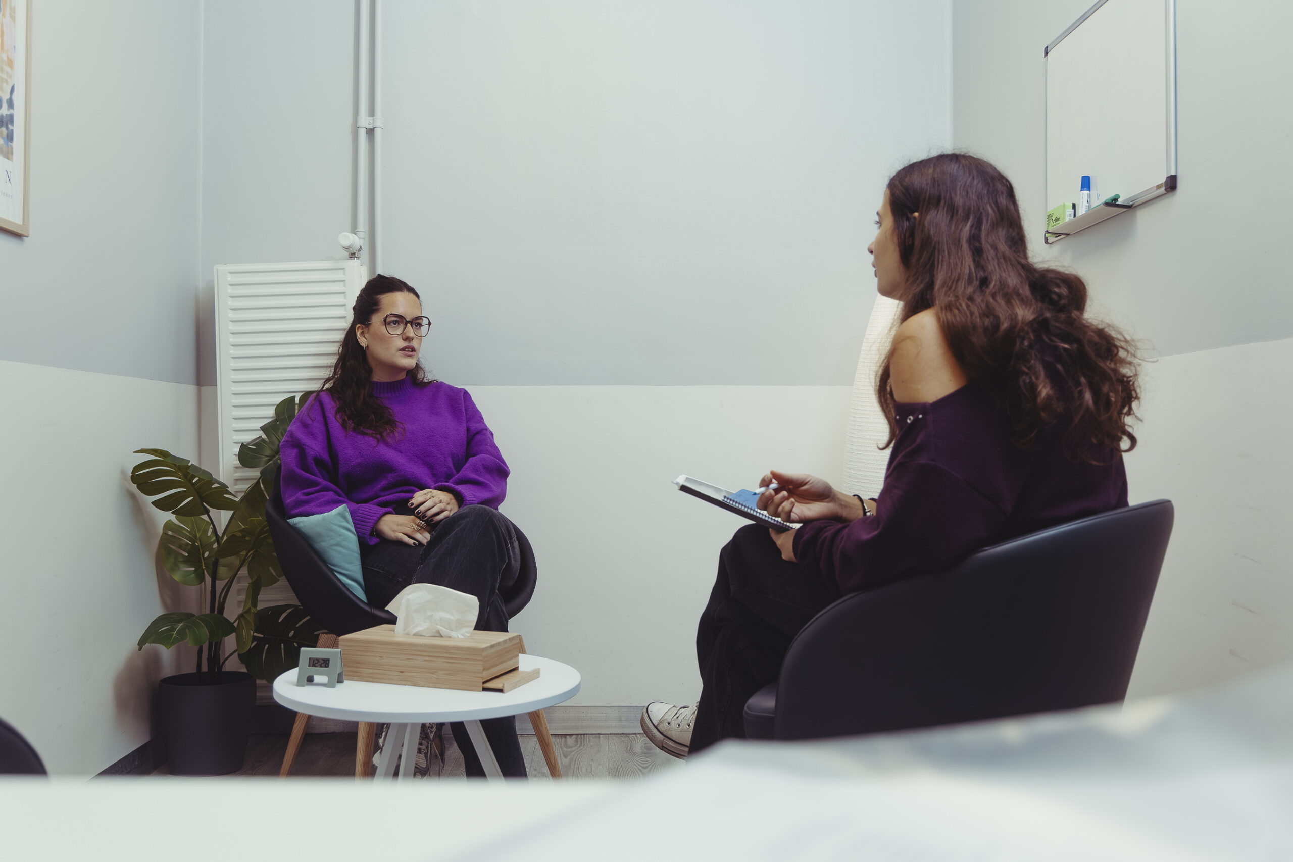 Une professionnelle prend des notes lors d'un entretien individuel