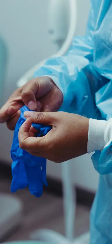 Une professionnelle de santé enfile des gants avant une consultation
